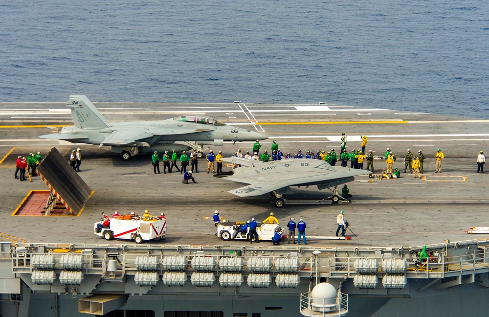 une vue aérienne d'un porte-avions avec un X-47B et un autre avion