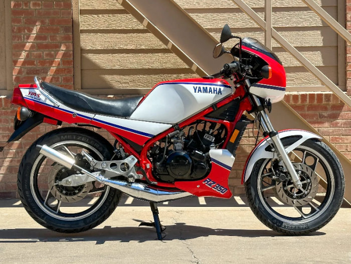 une Yamaha RZ350 1984 rouge métallisé, blanc et bleu, vue de profil droit
