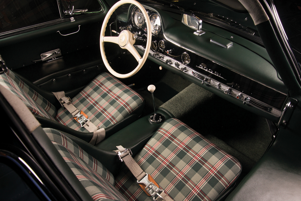 l'habitacle vert foncé, sièges en tissu à carreaux et ceintures de sécurité ventrale, avec le tableau de bord vu de la droite de la Mercedes-Benz 300 SL (W198) 1954