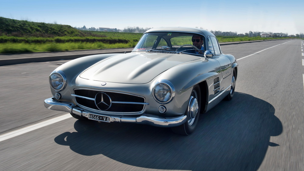 la Mercedes-Benz 300 SL 1955 gris métallisé, vue de 3/4 avant gauche, roule sur la une route