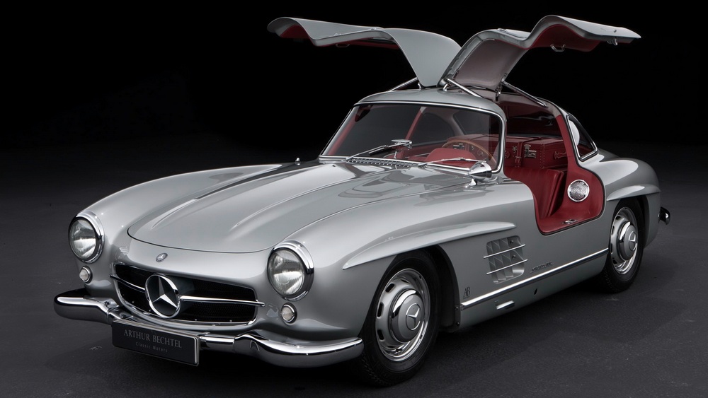 la Mercedes-Benz 300 SL 1955 gris métallisé vue de 3/4 avant gauche, intérieur rouge, portières ouvertes