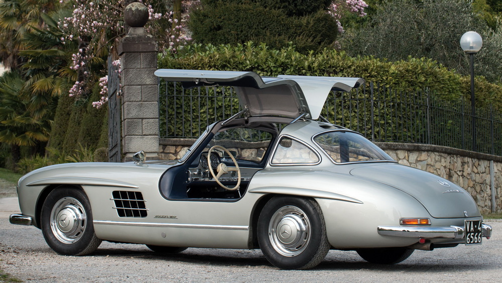 la Mercedes-Benz 300 SL 1955 gris métallisé vue de 3/4 arrière gauche, intérieur noir, portières ouvertes