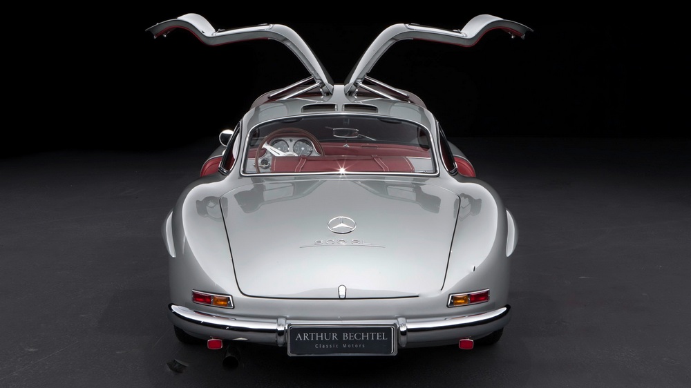 la Mercedes-Benz 300 SL 1955 gris métallisé vue arrière, intérieur rouge, portières ouvertes