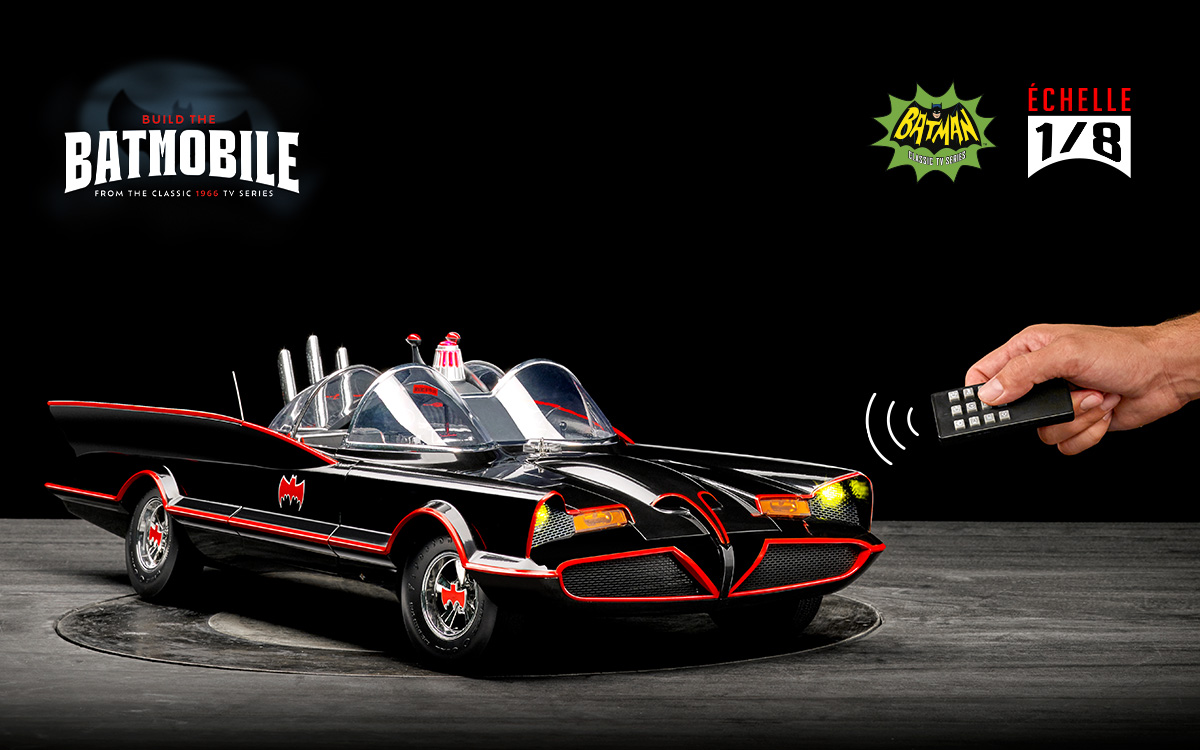 la maquette de la Batmobile 1966 avec une main qui tient la télécommande