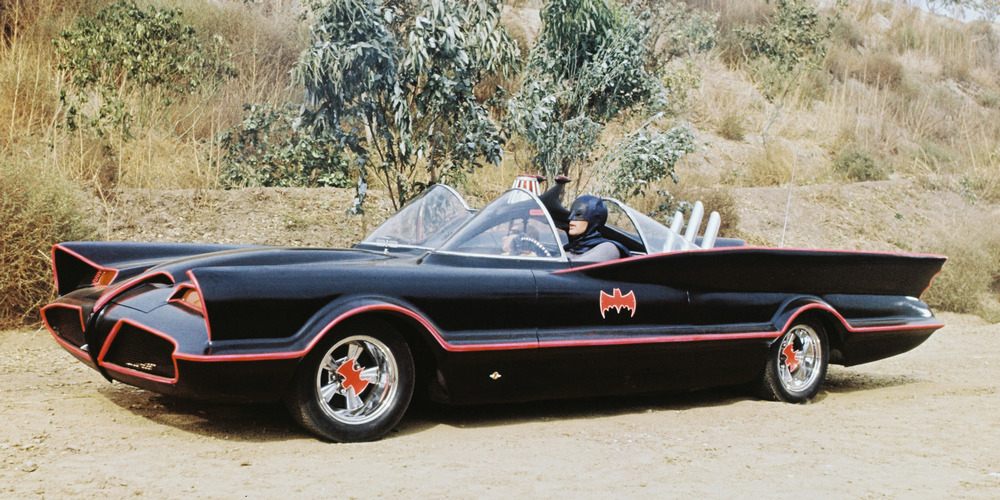 la Batmobile de 1966 vue de 3/4 avant gauche, avec Batman au volant