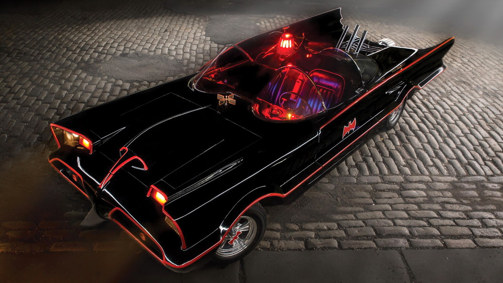 la Batmobile de 1966 vue de 3/4 avant gauche, légèrement aérienne, avec les phares, les feux et le girophare allumés